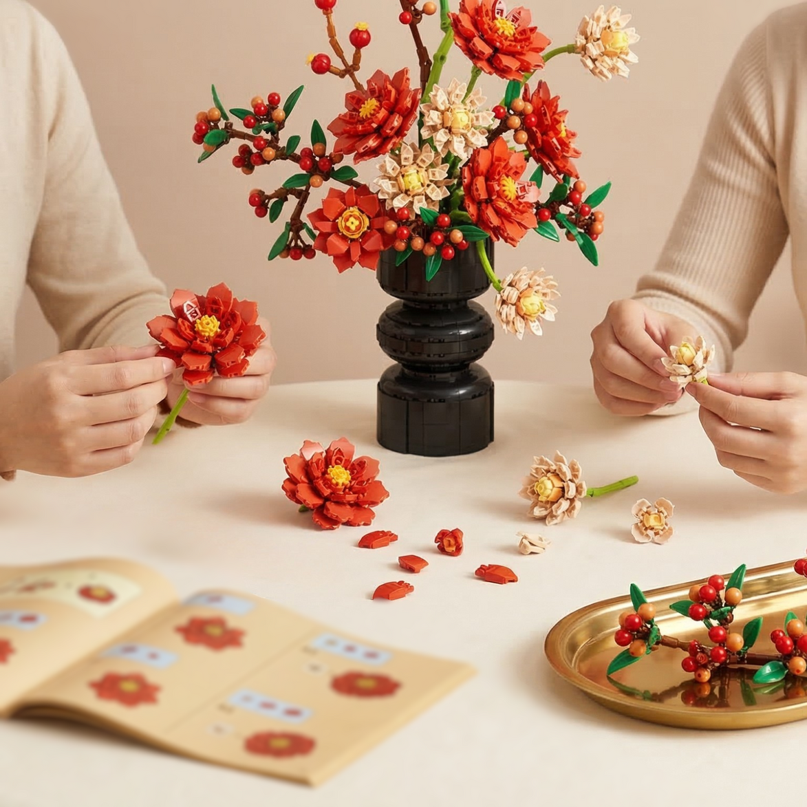 Two people assembling a Mavirea building block flower bouquet on a table, featuring vibrant red and cream blooms—a perfect creative activity and home decor piece.