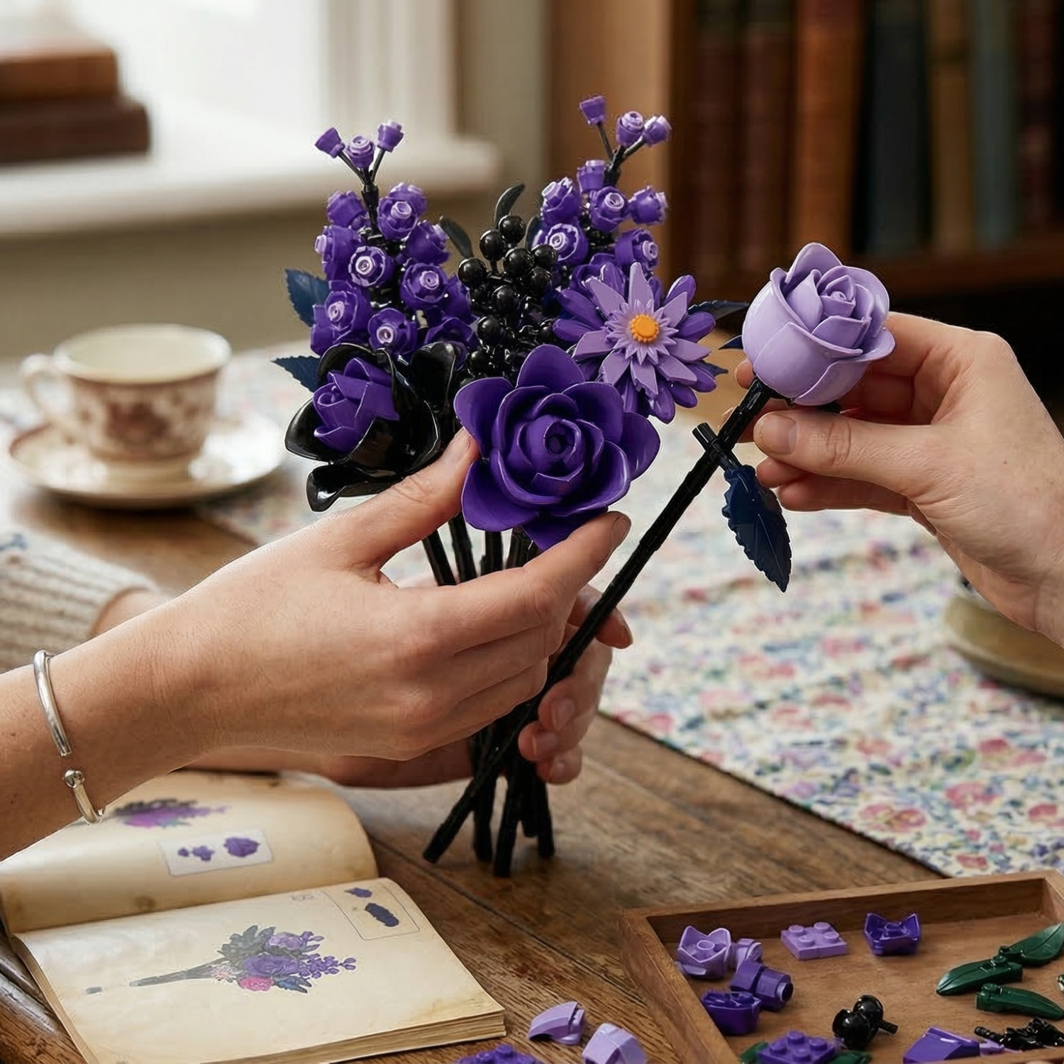 A finished Mavirea bouquet featuring a variety of purple building block flowers, held over an instruction manual to highlight its use as a stylish and maintenance-free home decor piece.