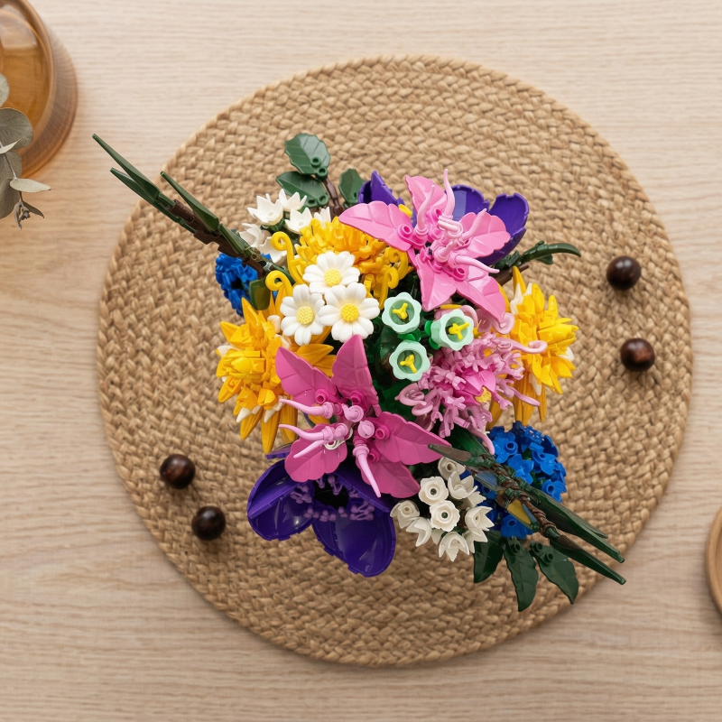 Top-down view of a colorful Mavirea building block arrangement on a woven placemat, showcasing detailed brick-built petals and textures.