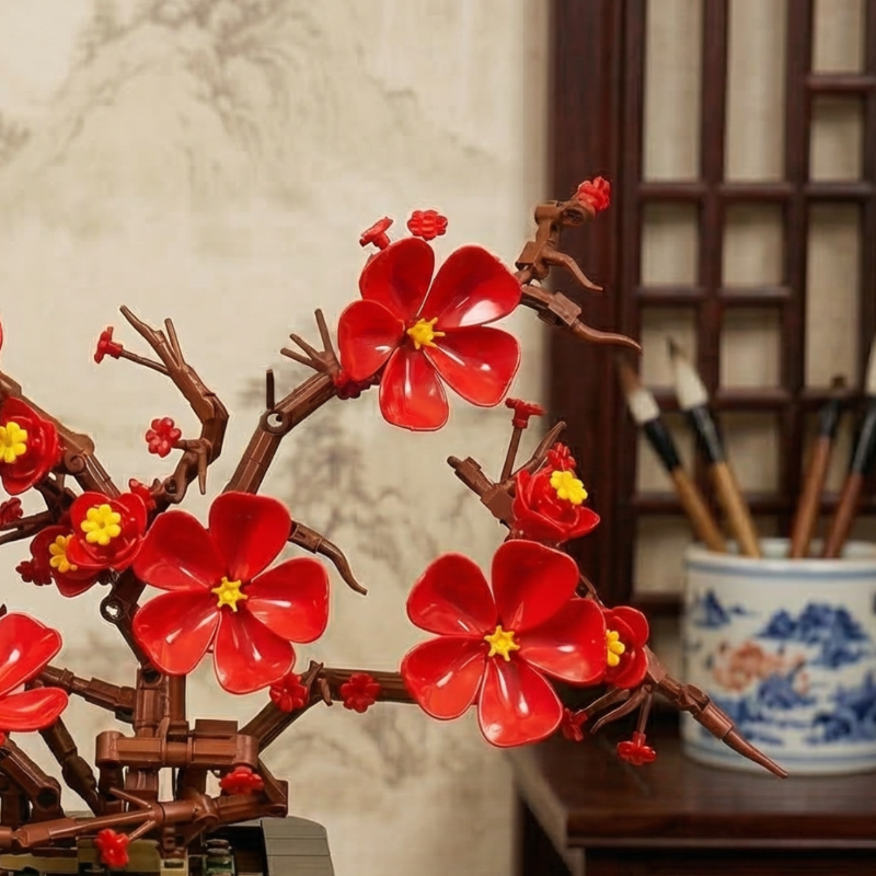 A close-up detail of the right branch of the Mavirea Plum Blossom Potted, focusing on the intricate red building block petals and yellow stamens that create a realistic, never-fading bloom.