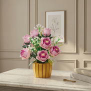 The Mavirea Pink Rose Potted Plant brick-built floral arrangement featured on a white marble tabletop, creating a timeless decorative scene against a backdrop of framed botanical wall art.