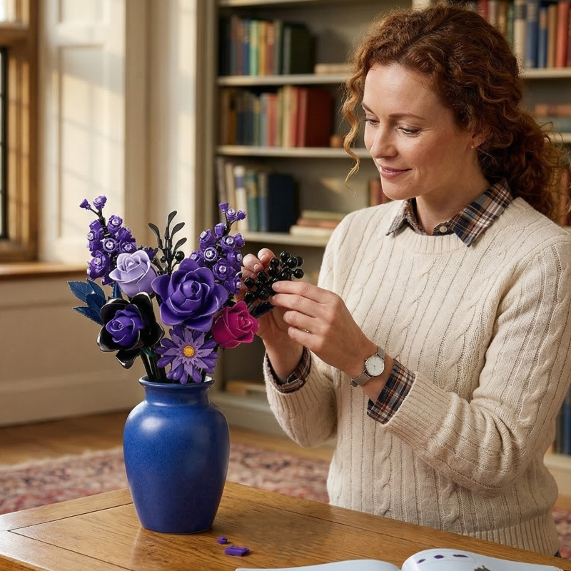Capturing the joy of a creative hobby, a woman smiles while adding the finishing touches to her Mavirea Purple Rose Whisper bouquet in a vibrant blue vase, making it a perfect eternal gift for a loved one.