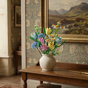 An elegant Mavirea Spring Pastel Bouquet displayed in a traditional interior, blending building block artistry with classic floral wallpaper and landscape art.