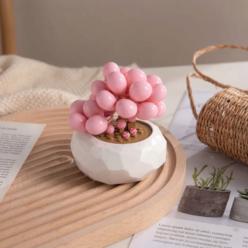 Mavirea’s pink Graptopetalum Amethystinum succulent building block displayed on a wavy wooden tray, an artistic and everlasting gift for minimalist interiors.