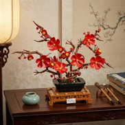 A Mavirea Plum Blossom Potted building block set displayed on a dark wood console under warm, soft lighting, featuring vibrant red blooms that bring a Zen-inspired aesthetic to modern home decor.